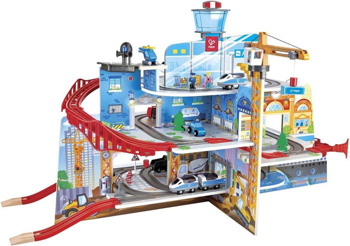 Multi-level wooden toy city with red tracks, yellow crane, blue control tower, trains, and vehicles.
