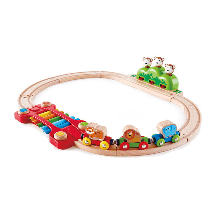Oval wooden train track with colorful animal cars, a rainbow xylophone bridge, and three monkeys on a green hill.