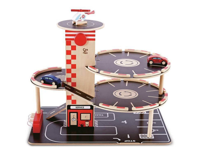 Multi-story wooden toy garage with red-striped tower, circular parking decks, ramps, two cars, and a helicopter.