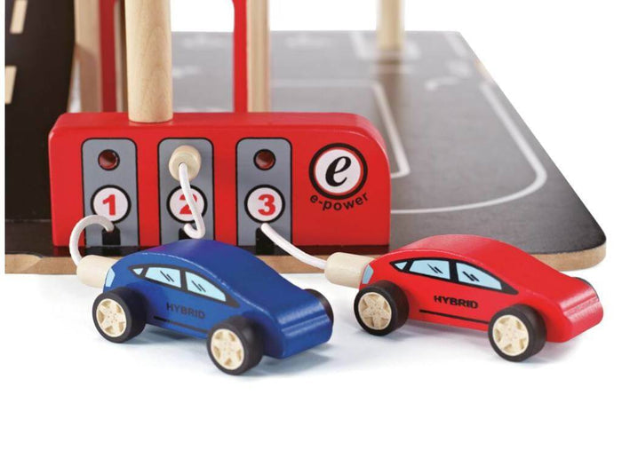 Red and blue wooden hybrid toy cars plugged into a red e-power charging station with numbered ports.