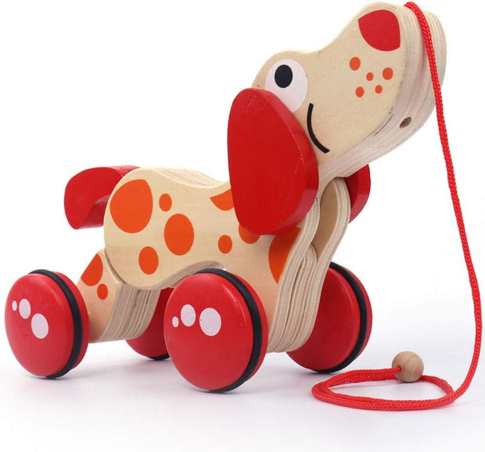 Wooden toy dog with orange spots, floppy red ears, and red wheels on a red pull string.