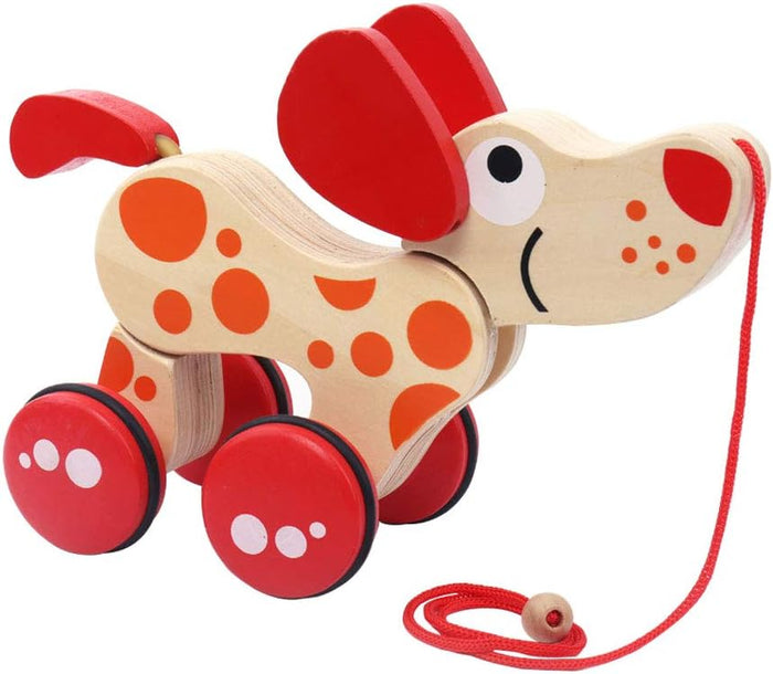 Spotted wooden toy dog with large red floppy ears, four red wheels, and a red pull cord.
