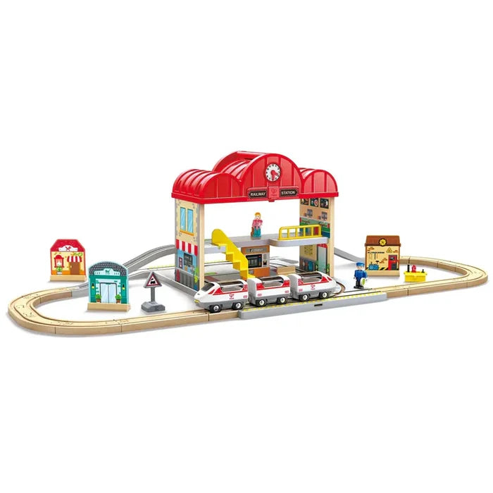 Colorful wooden train set with a two-story red station, white train, and figurines on an oval track.