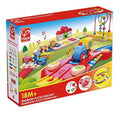 Red Hape box showing a wooden toy train on colorful musical tracks with a xylophone, bead maze, and bright blocks.