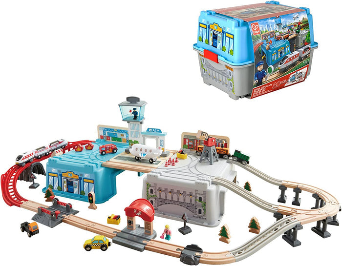Toy city transport set with wooden tracks, trains, and an airplane, integrated with a blue and grey storage bucket.