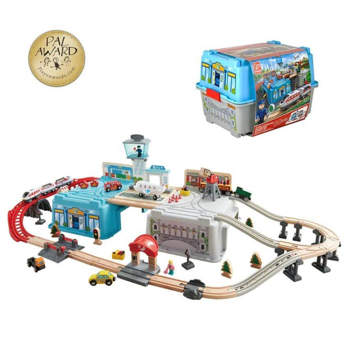Wooden transport toy set with tracks and vehicles built around a blue storage bucket, shown both assembled and packed.