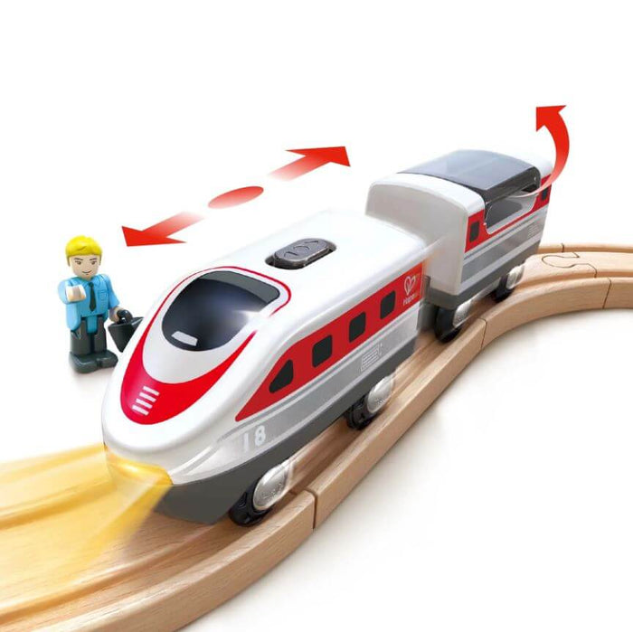 White and red toy bullet train on wooden tracks with a conductor figurine, glowing headlight, and motion arrows.