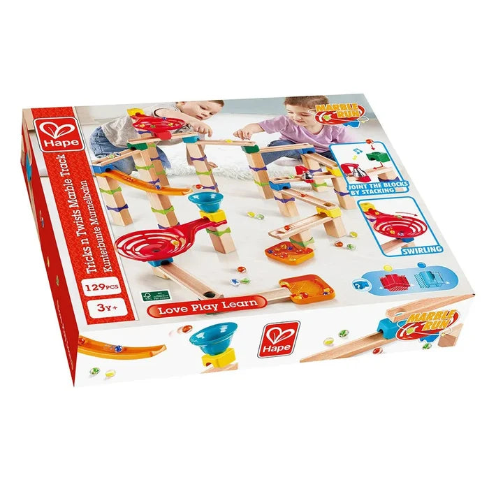 Red Hape box showing a 129-piece wooden marble run with colorful plastic funnels and children building the track.