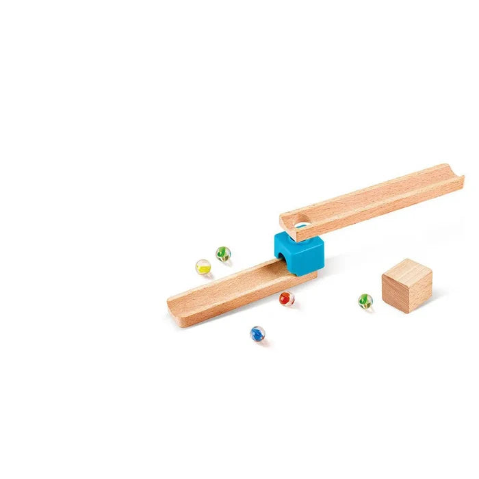 Two natural wood ramps joined by a blue connector, with colorful glass marbles and a wooden cube on a white background.