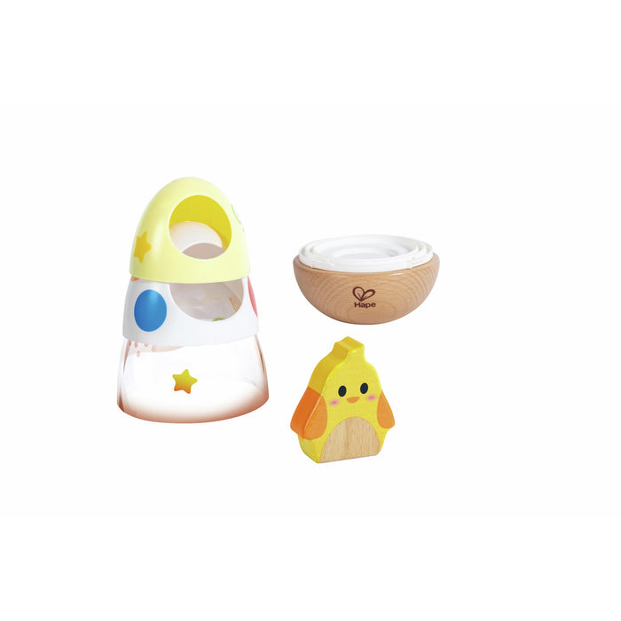 Stackable toy with clear, white, and yellow tiers, a wooden wobble base, and a small yellow wooden chick figure.