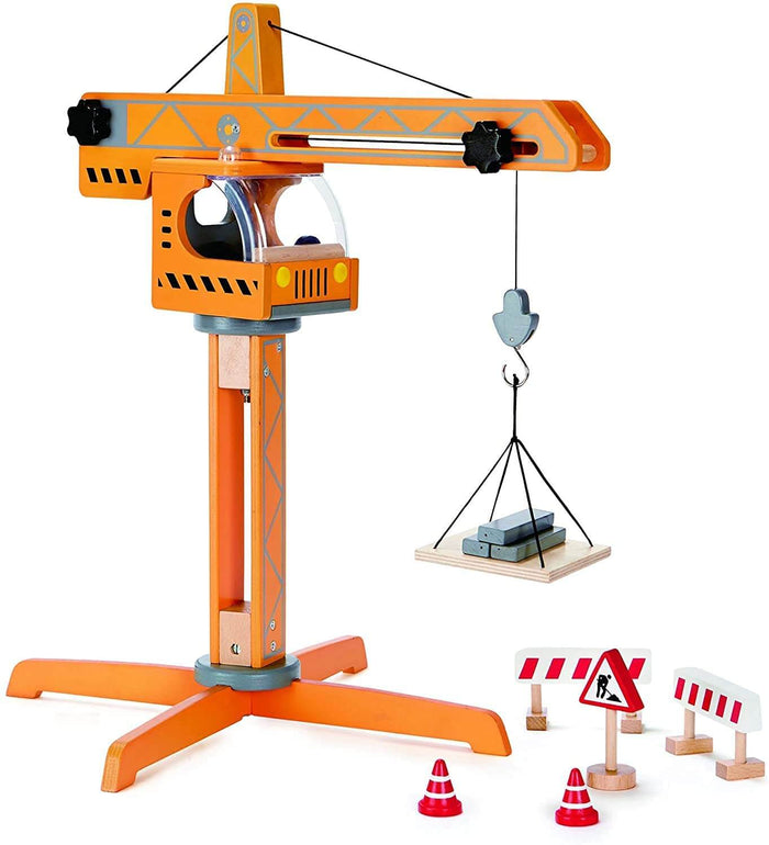 Orange wooden toy crane lifting a pallet of grey blocks, including toy traffic cones and construction signs.