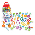 Colorful plastic scoopers, tweezers, and spiral tools next to a clear storage jar with a red handle lid.