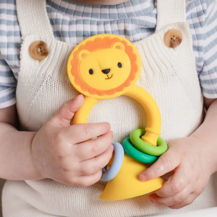 Baby holding a yellow silicone lion toy with an orange mane, colorful sliding rings, and a suction cup base.