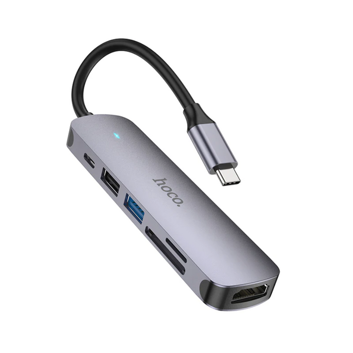 Techplus Hoco PD 100W USB-C 6-in-1 Adapter Hub with multiple ports for charging and data transfer, connected to a laptop.