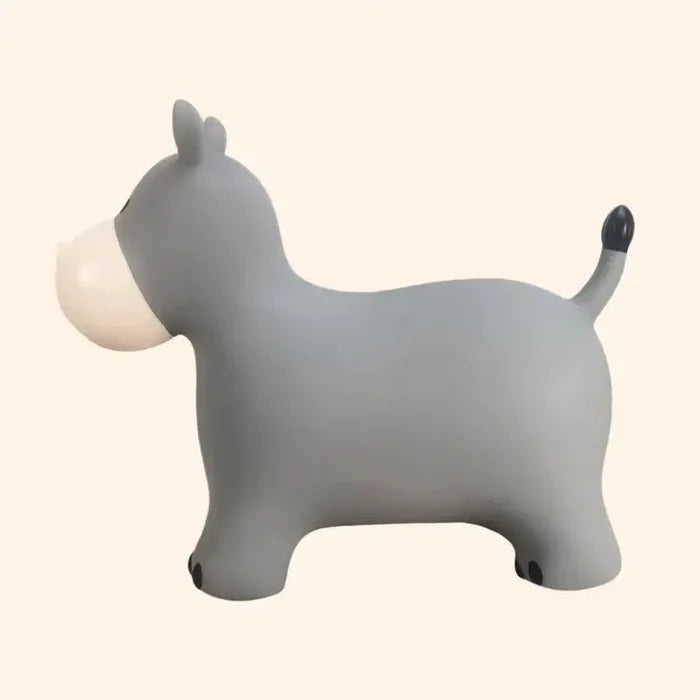 Side view of a gray hippo-shaped inflatable bouncer toy with a cream snout and black hoof markings.