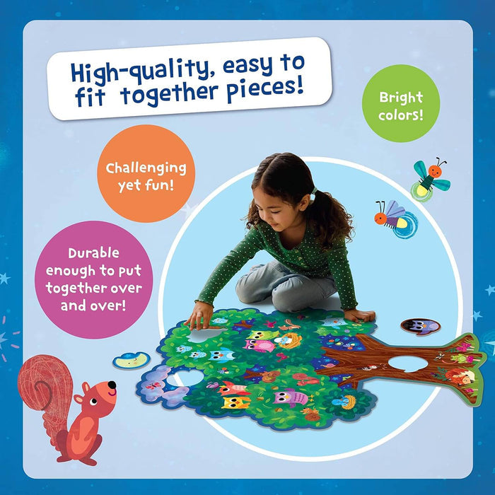 Girl assembling a large tree-shaped floor puzzle with colorful owl pieces on a blue background with stars.