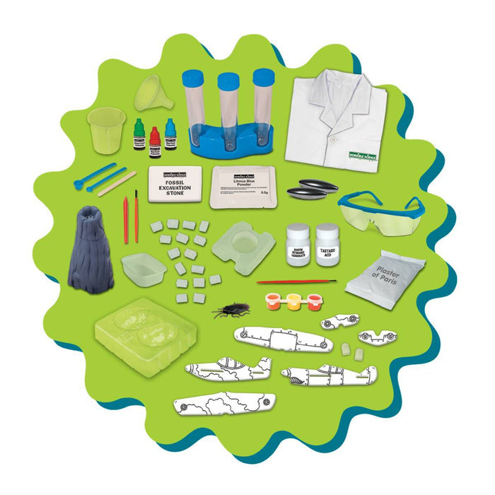 Science kit with lab coat, goggles, test tubes, volcano model, and chemical powders on a green splat background.