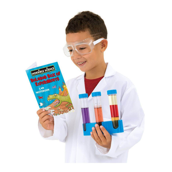 Child in a lab coat and goggles holding a science notebook and a rack of test tubes with colorful liquids.