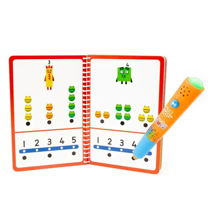 Open activity book with colorful block characters and an orange electronic pen touching an interactive black dot.