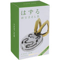 Green and white box showing a silver metal oval with maze-like grooves and two interlocked gold-toned metal rings.