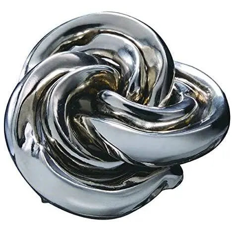 Interlocking silver and gold metal pieces in a compact, swirling vortex shape with a reflective, polished finish.