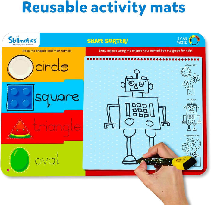 Colorful shape-sorter activity mat with tracing sections and a hand drawing a robot on the large drawing grid.
