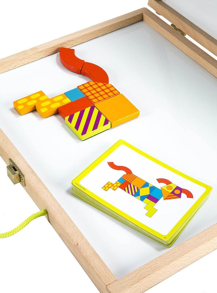 Patterned magnetic blocks on a whiteboard in a wooden case with design cards showing a colorful dog pattern.