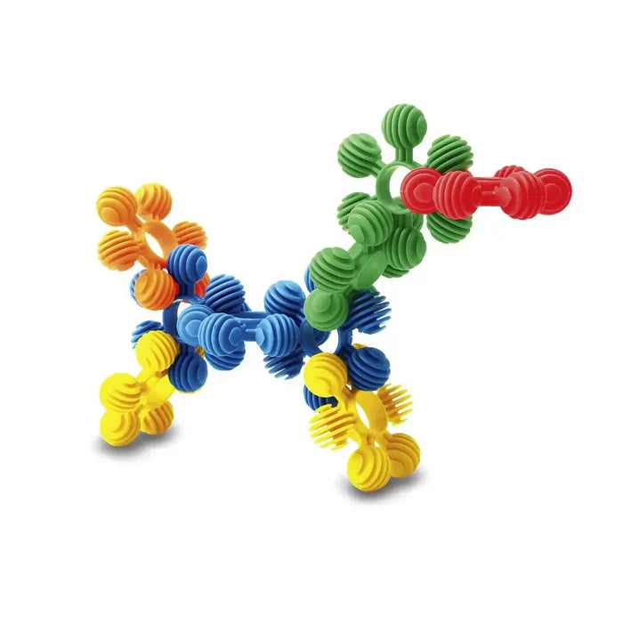 A toy dog figure built from interlocking red, green, blue, and yellow plastic rings and ribbed spheres.