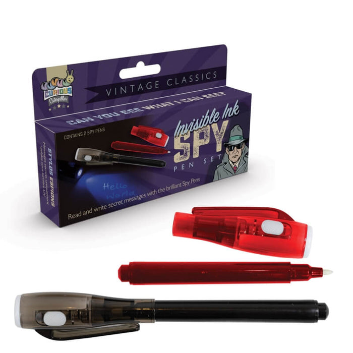 Purple vintage spy pen box next to a black pen and a red pen with its light-up cap removed showing a white felt tip.