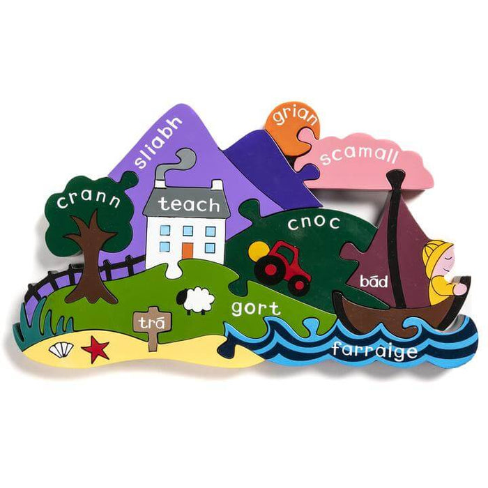 Colorful wooden jigsaw puzzle of a landscape with Irish labels for the mountain, house, trees, and sea.
