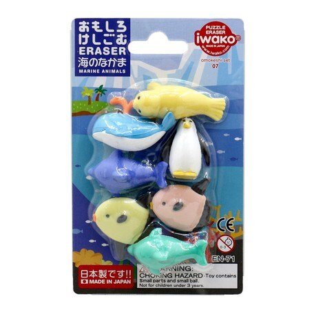 Seven colorful marine animal erasers including a whale and penguin in a blue blister pack with Japanese text.
