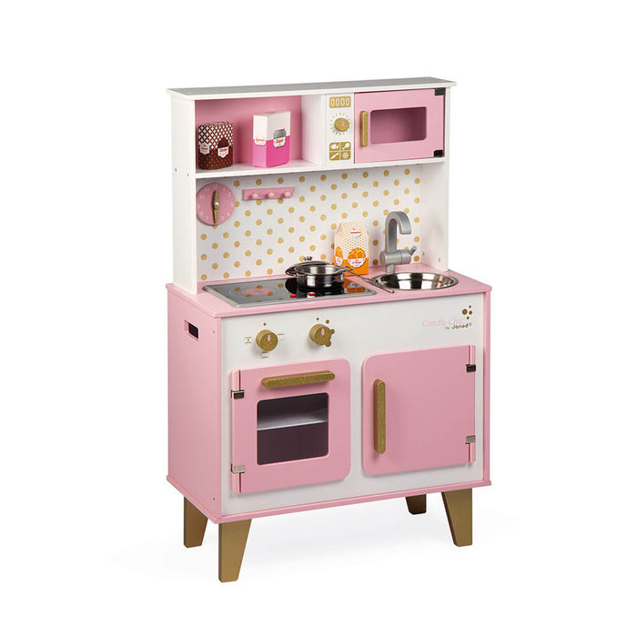 Pink and white wooden play kitchen with oven, stovetop, sink, microwave, gold handles, and polka dot backsplash.