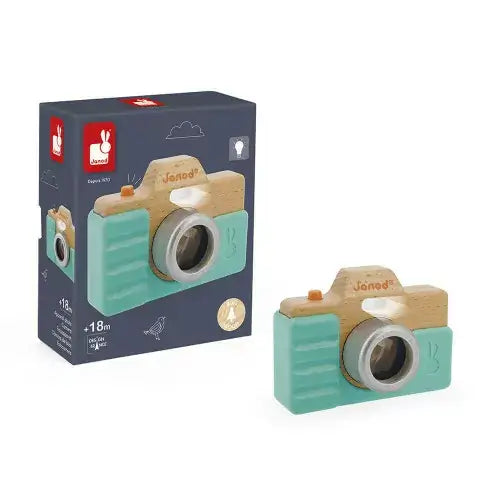 Mint green and wood toy camera with an orange button and grey lens, shown next to its dark blue illustrated box.