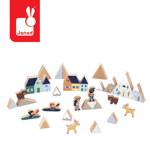 Wooden block set featuring triangular mountains, houses, bears, and deer with hiker figures in soft, natural colors.