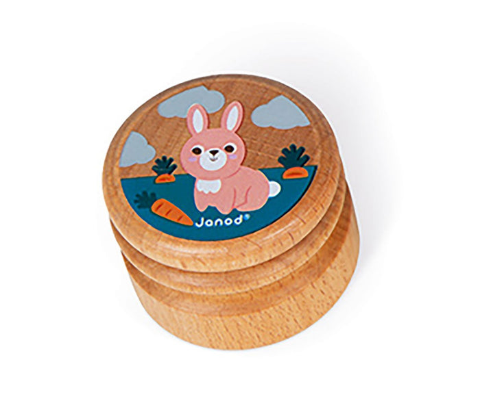 Round wooden box featuring a pink cartoon rabbit with carrots on a blue field and gray clouds.