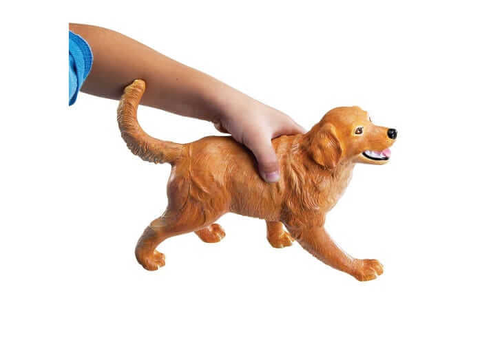 Child's hand holding a large golden-brown toy dog with realistic fur texture and a happy expression.