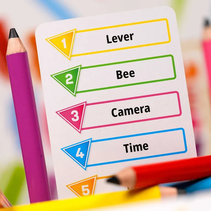 White game card with numbered, colored slots containing words Lever, Bee, Camera, and Time, framed by colored pencils.