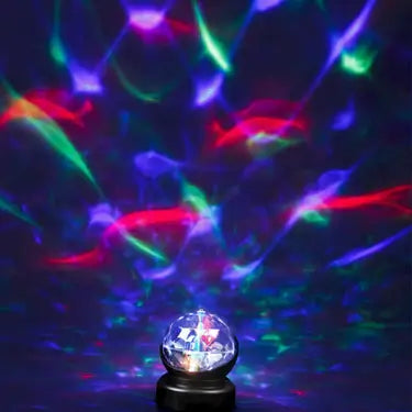 Small dome lamp projecting vibrant red, green, and blue kaleidoscopic light patterns onto a dark background.