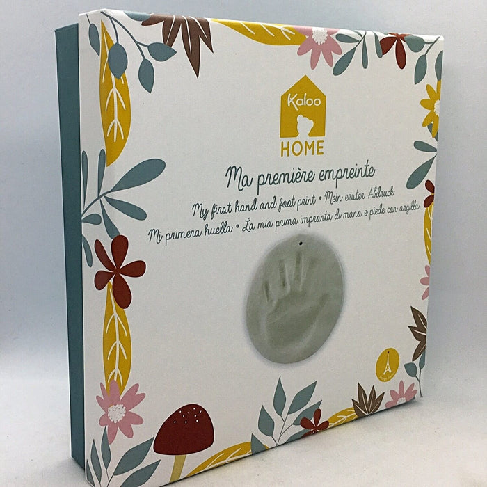 White square gift box with floral illustrations and a circular grey baby handprint clay impression.