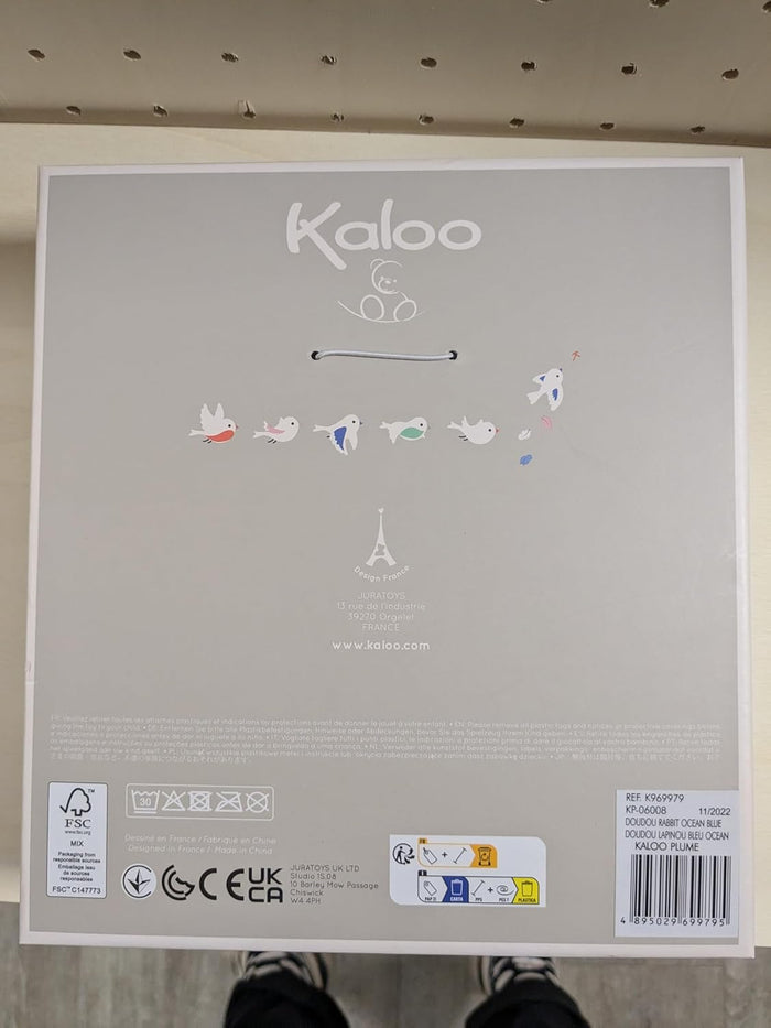 White square box back with Kaloo logo, bird illustrations, safety symbols, and product information labels.