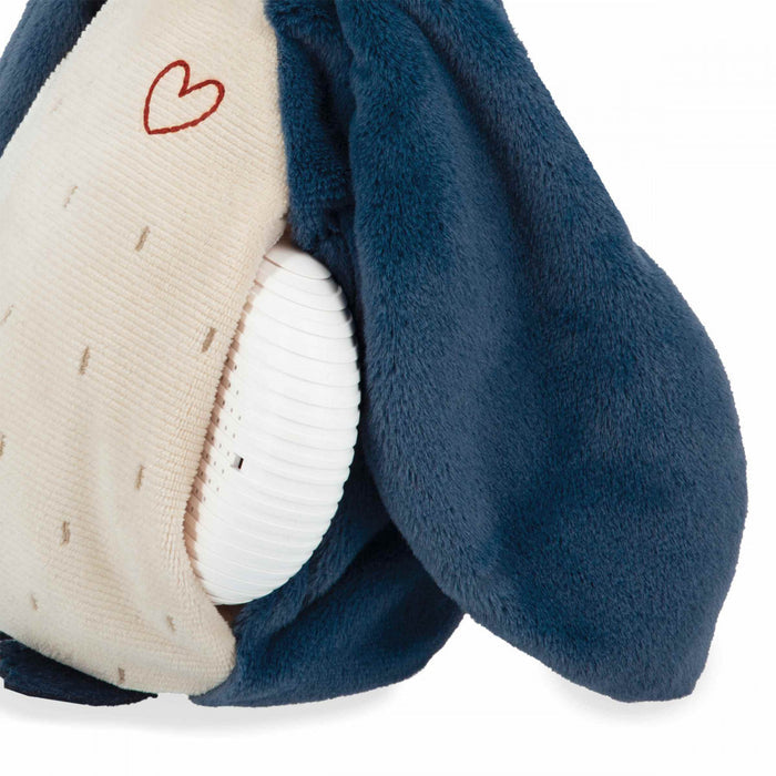 Blue plush toy with a cream belly and red heart, showing a white ribbed sound module tucked into a side pocket.