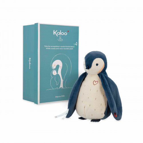 Navy and cream penguin plush with a red heart, next to a teal gift box featuring white penguin illustrations.