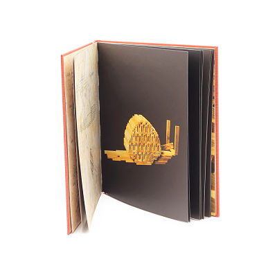 Open red book featuring a snail sculpture made of wooden planks on a black page.