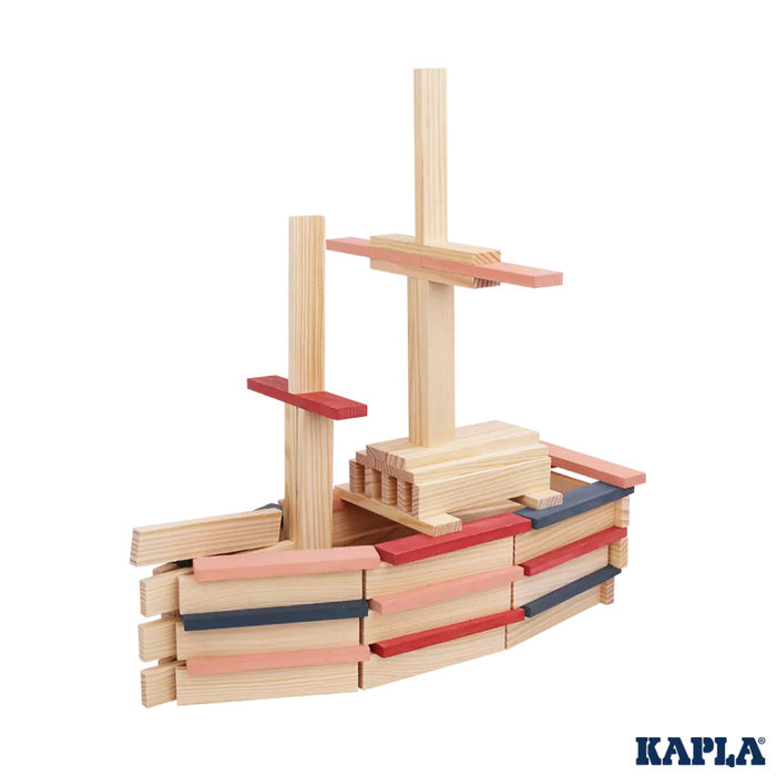 Ship built from light wood blocks with pink, red, and blue accents on the hull, masts, and yardarms.