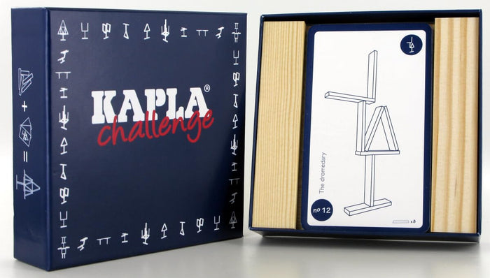 Dark blue game box beside open tray of light wooden planks and a challenge card with a complex building diagram.