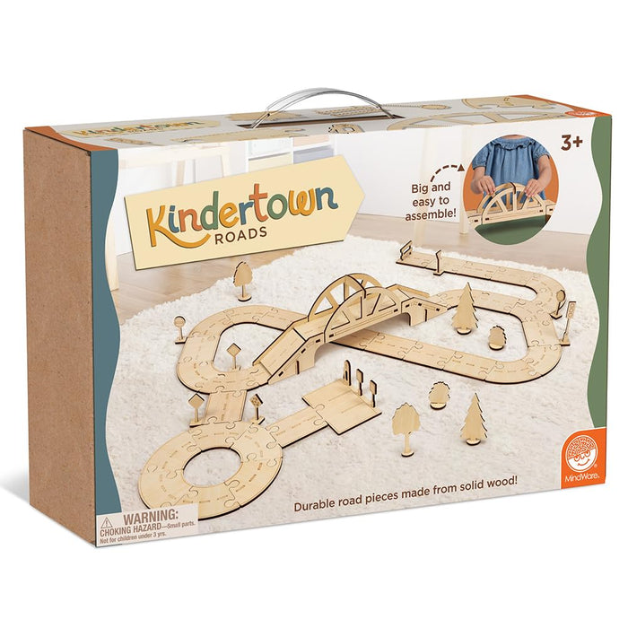 Box for a wooden road set with natural wood jigsaw tracks, a large arched bridge, and small trees on a white rug.