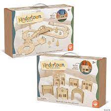 Two boxes of Kindertown wooden toys featuring natural wood roads with a bridge and a set of village buildings.