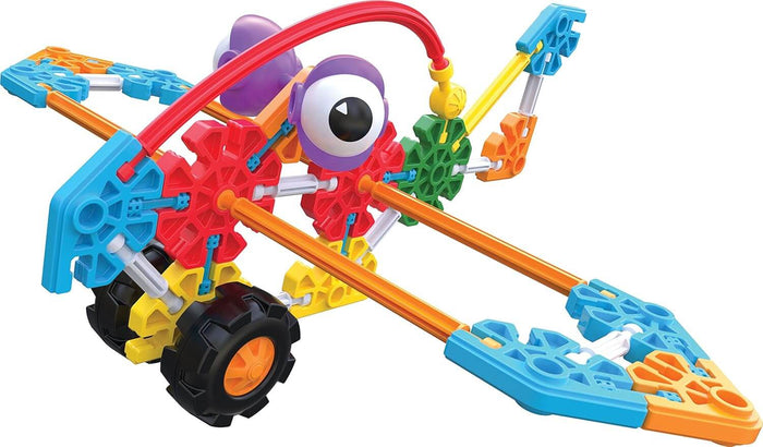 Colorful toy creature built with K'NEX pieces, featuring chunky black wheels, red rods, and a large purple eye.