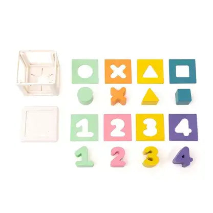 White shape sorter cube with pastel geometric blocks and numbers 1-4 with matching cutout panels.