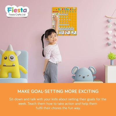 A girl pointing at a yellow magnetic chart on a pink wall, with yellow and blue plush character toys nearby.